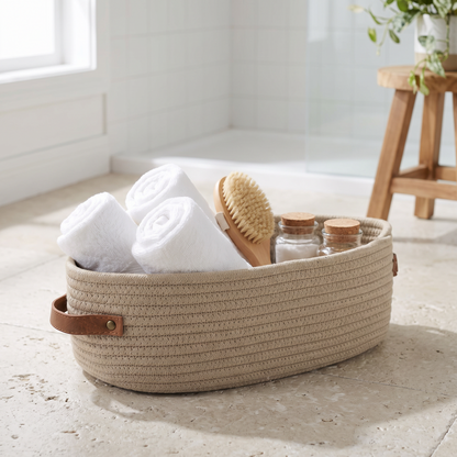 Oval storage basket holding towels in a bathroom